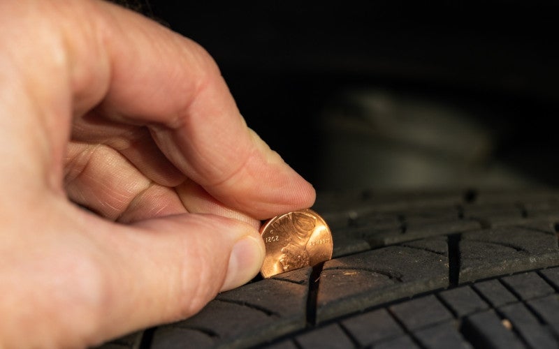 technician putting coin in tire